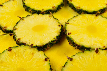 Pineapple juicy yellow slices background. Top view.