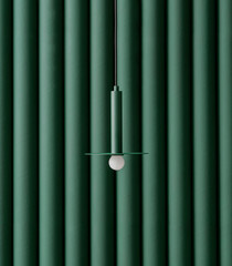 Dark green metal lamp hanging on folded colorful wall background in studio