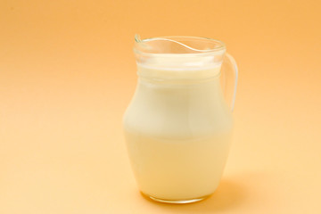 A jar with a milk on a beige background. Space for text or design.