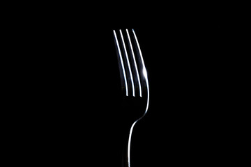 Fork on a black background with light from the side
