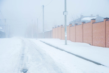 winter road in the summer cottage with thick fog