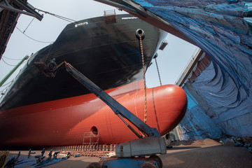 The bulk carrier general cargo ship in dry dock yard, recondition of hull repairing and repaining,...