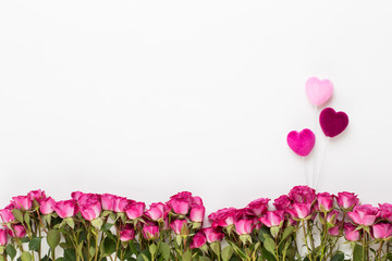 Flowers composition. Frame made of red rose on white wooden background. Flat lay, top view, copy space.