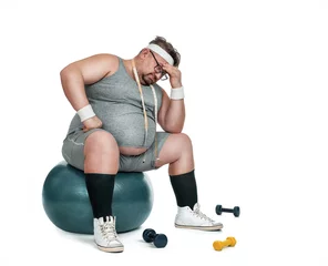 Rollo Lustiger übergewichtiger Sportler, der deprimiert auf dem Fitnessball sitzt, isoliert auf weißem Hintergrund © rangizzz