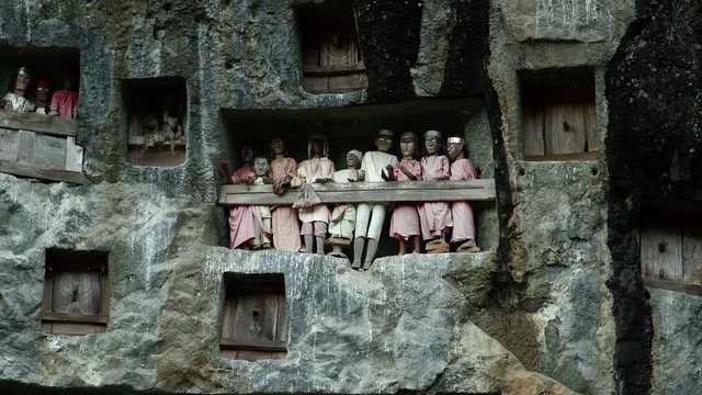 Famous funeral of Tana Toraja.Typical Toraja tombs in a vertical rock wall carved with traditional puppets in memory of the dead, Toraja Land, Sulawesi, Indonesia