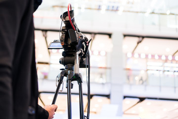 Rear side of Video Cameraman taking recording film photograp to stage in Live streming event and seminar hall. Media Production equipment concept