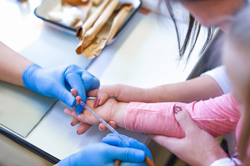 The doctor takes blood tests from the finger of the child with the mother
