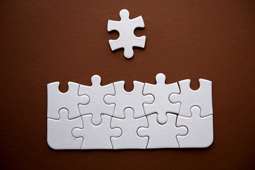 Close-Up Of Solved Jigsaw Puzzle On Brown Background