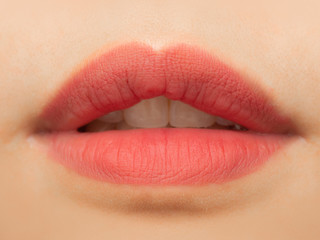 Fototapeta premium Close up view of beautiful woman lips with pink matt lipstick. Open mouth with white teeth. Cosmetology, drugstore or fashion makeup concept. Beauty studio shot. Passionate kiss