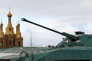 Infantry fighting vehicle as a monument on the background of the church