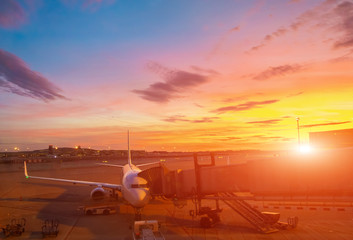 Airplane at the terminal gate ready for takeoff. International airport during colorful sunset - Concept  Travel around the world
