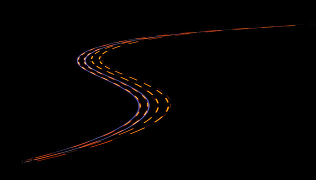 Light trail from cars driving an double bended curve in the night
