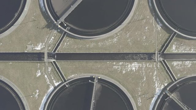 Sewage farm. Static aerial photo looking down onto the clarifying tanks. Industrial place. Geometric background texture. Photo captured with drone.  DJI Mavic 2 Pro 4k dlog-m ungraded flat.