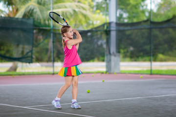 Child playing tennis on outdoor court