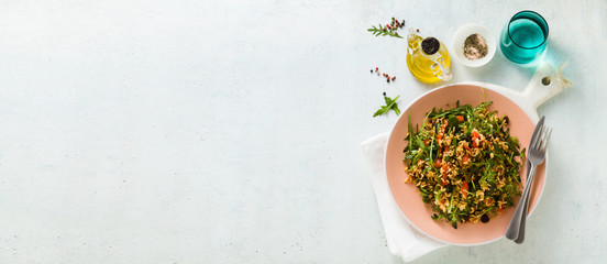 banner of rice salad with baked bell peppers, arugula, olives and capers. Healthy vegan spring...