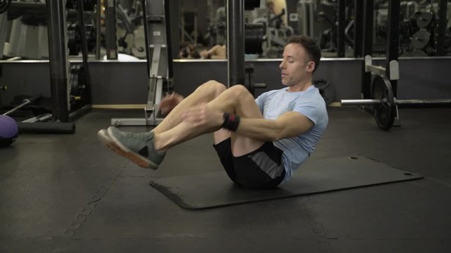 Image of a muscular man doing abdominal exercise at the gym.