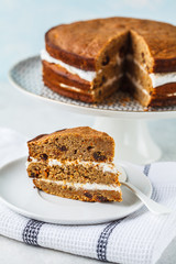 Vegan carrot cake with coconut cream, white background.