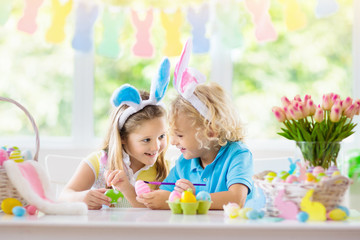 Kids on Easter egg hunt. Children dye eggs.