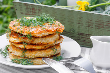 Delicious pancakes from courgettes and fresh vegetables with sour cream and dill
