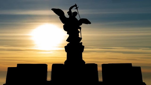Rome: Bronze statue of Michael the Archangel in Silhouette at Sunset, standing on top of the Castel Sant'Angelo or Castle of the Holy Angel (Mausoleum of Hadrian), Italy, Europe