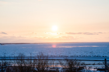 Fototapeta na wymiar 冬のオホーツク海　流氷と夕日（北海道・斜里町）