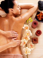 Masseur doing massage on woman back in spa salon