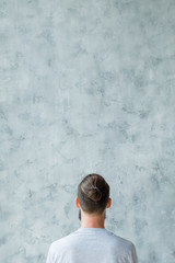 Think different concept. Man backview. Copy space on grey textured background.