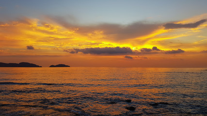 Rocks rock along the beach sand in the twilight. 