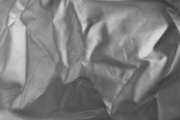 Holographic texture fabric silver colors with folds. Holographic color wrinkled crumpled foil. Silver background.