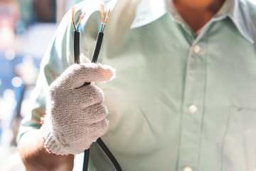 The electrical technician is holding the power cord for installation.