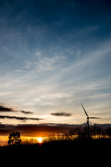 Fototapeta na wymiar Silhouette of wind turbines on the mountain at sunset.