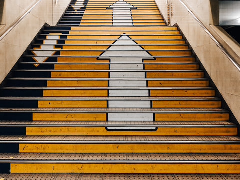 Big arrows direction symbol on concret stair in subway in Japan. there is seperate the walk way clearly. Line up and down.