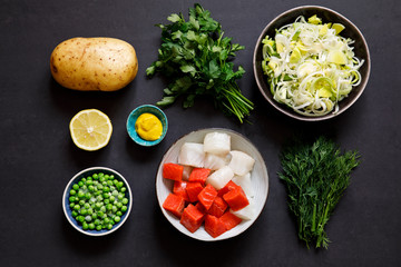 Fish pie ingredients on black background