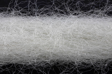 extreme close-up of a white woolen thread on black background