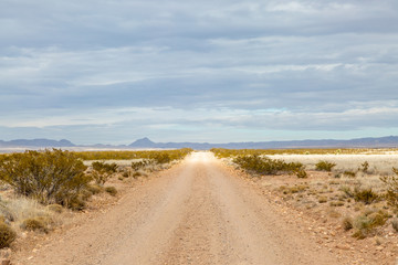 Looking along a long straight road in rural New Mexico