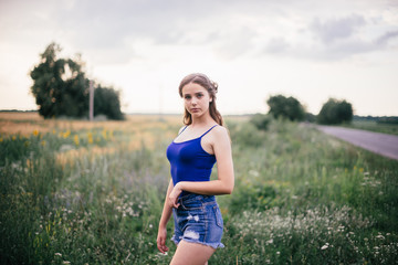 Beautiful girl in short shorts and in a blue T-shirt on the field