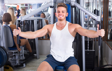 Fototapeta na wymiar Young man using fly machine in gym.