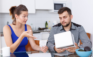 Unhappy young woman and man with box of purchase having conflict