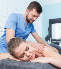 Obraz na płótnie Canvas Massagist doing massage to woman in wellness center