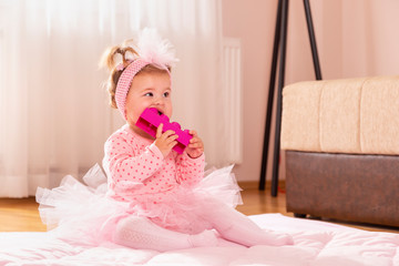 Baby girl chewing toy blocks