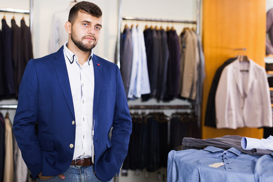 Smiling man shopper choosing fashion jacket