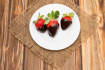 berry ripe strawberries in chocolate on a wooden background.