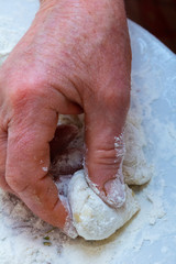 Grandmother cooks dumplings on kitchen