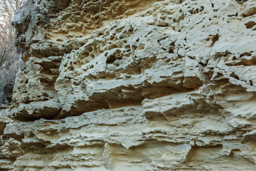 Picturesque background of collapsing surface of limestone rock. Abstract beautiful forms of weathering stone rocks, huge cracks and washed cavitie in stone, danger of collapse and landslide earthquake