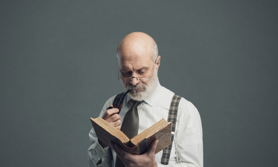 Senior academic professor reading and smoking a pipe