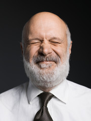 Cheerful senior businessman portrait on black background
