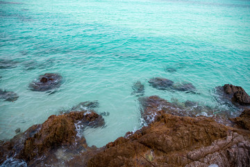 tropical beach rock and Soft wave of blue sea in summer