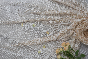 The texture of lace on wooden background decoreted roses.