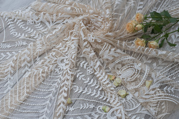 The texture of lace on wooden background decoreted roses.