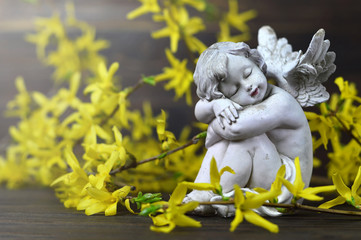 Angel guardian and yellow forsythia flowers